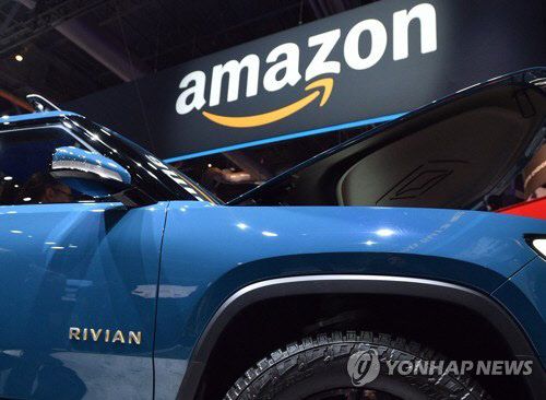 아마존 로고를 배경으로 촬영된 리비안의 전기 픽업트럭